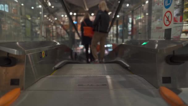 Escalera plana en un supermercado. Ascensor y clientes con una cesta de comestibles bajando por la vista trasera, personalidad irreconocible — Vídeos de Stock