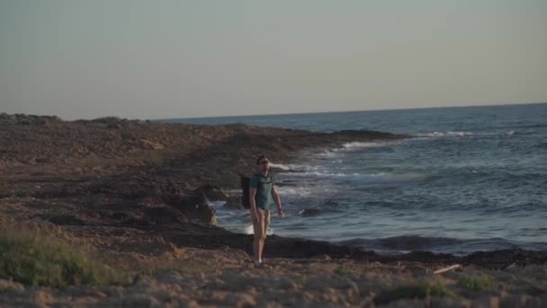 A male tourist with a backpack admiring the view of the mediterranean sea on the rocky coast of the island of Cyprus in the city of paphos at sunset — Stock Video