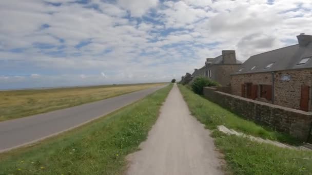 The theme is a bicycle trip through the north of France, the region of Brittany and Normandy. POV view of cyclists on a gravel bike and walk path along the ocean in Saint-Malo — ストック動画