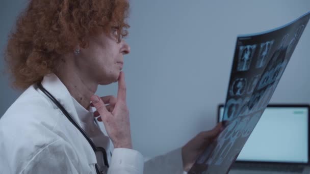 Mulher branca madura médico radiologista examinando tomografia computadorizada de pacientes tórax e pulmões em consultório hospitalar — Vídeo de Stock