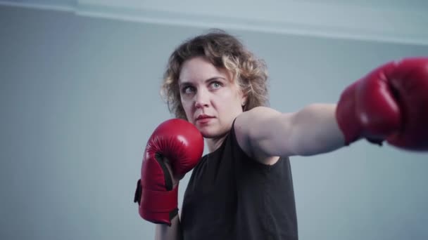 Belle femme sportive posant avec des gants de boxe — Video