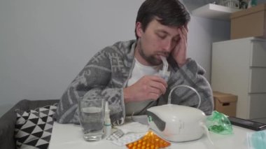 Adam zatürree sırasında evde solunum yapıyor. Coronavirus covid 19 enfeksiyonu. Tıbbi sprey, nebulizör, nebula. Astım tedavisi. Bronşit, astımlı sağlık ekipmanları