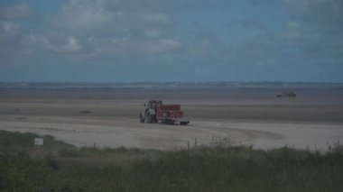 Balıkçılar, Britanya 'nın kuzeyindeki Atlantik Okyanusu' nun alçak gelgitleri sırasında istiridye ve kabuklu deniz hayvanı toplamak için traktöre biniyorlar.