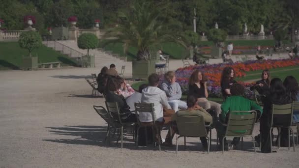 Studenter under träning i friluftsliv sitter på stolar i cirkel och lyssnar på lärare i Luxembourg Gardens i Paris, Frankrike den 4 september 2021. Le Jardin du Luxembourg. Allmänna trädgårdar och franska senaten — Stockvideo