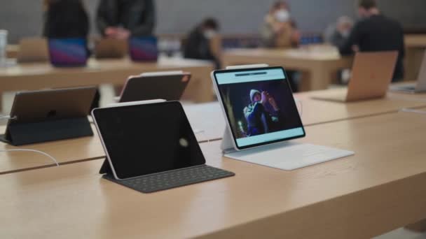12 Mart 2022 Berlin, Almanya. Kurfuerstendamm 'daki Apple Store. Alıcılar yeni aletleri ve şirketin ürünlerini vitrinde izliyorlar. — Stok video