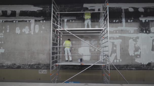2022年4月20日 慕尼黑 慕尼黑地铁站的整修 两名杂工正在整修德国地铁站的内部 用粉刷工具修整旧墙体的建筑商 — 图库视频影像