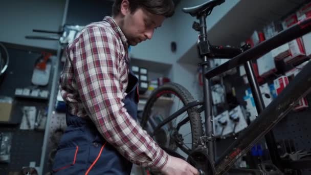 Zmęczony Mechanik Rowerowy Pracujący Sklepie Rowerowym Naprawiający Rowery Klientów Naprawiacz — Wideo stockowe