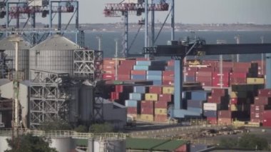 Odessa 'daki kargo konteynırı terminali. Limanda çalışan vinçleri olan kargo iskelesi. Vinç köprüsü altında, Odessa, Ukrayna 'da büyük bir kargo gemisi. Konteynır ihracatı lojistik, kargo limanı