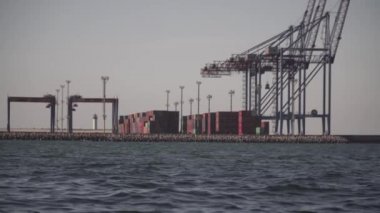 Odessa 'daki kargo konteynırı terminali. Limanda çalışan vinçleri olan kargo iskelesi. Vinç köprüsü altında, Odessa, Ukrayna 'da büyük bir kargo gemisi. Konteynır ihracatı lojistik, kargo limanı