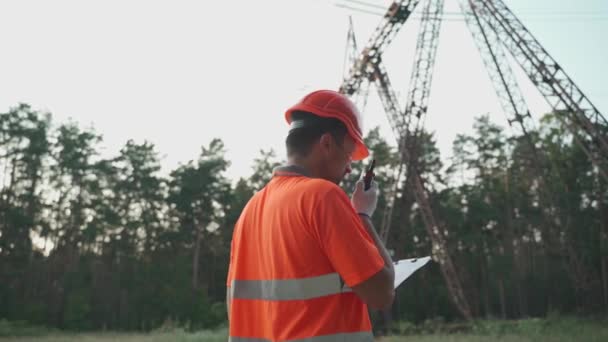 Pracownik Elektrowni Wychodzi Raportuje Przez Walkie Talkie Sprawdzając Dane Schowku — Wideo stockowe