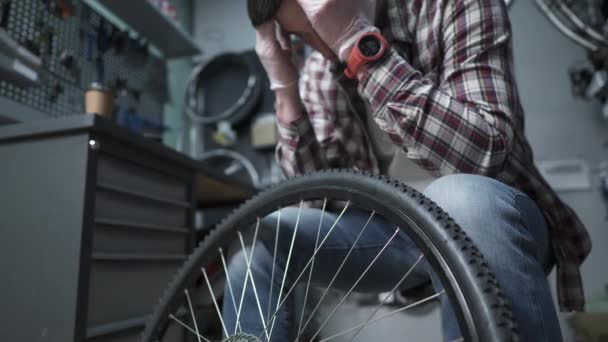 Trött Cykelmekaniker Dricker Kaffe Från Engångskopp Kartong Sin Arbetsplats Cykelaffären — Stockvideo