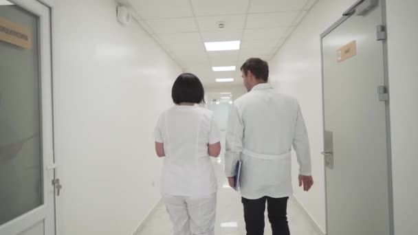Rear View Two Doctors Man Woman Walking Hospital Corridor Talking — Stock Video