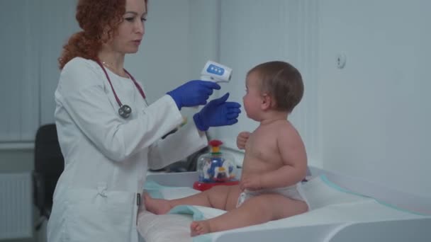 小児科医の概念 小児科医 診療所で小児科医に診察された1歳の少女 健康診断のために訪問する子供 医者は小さい患者を調べる — ストック動画