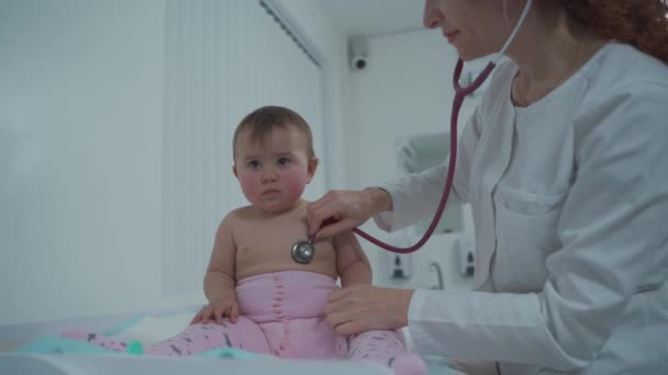 小児科医の概念 小児科医 診療所で小児科医に診察された1歳の少女 健康診断のために訪問する子供 医者は小さい患者を調べる — ストック動画
