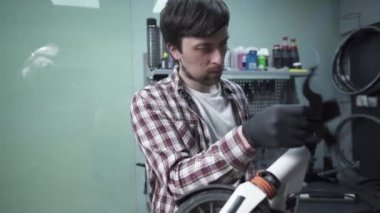Tamirhanedeki tamirci tamirden önce scooter 'ı temizliyor. Tamir etmeden önce motor parçalarından toz ve kir kaldırıyor. Bisiklet ve scooterların tamiri ve ayarlanması
