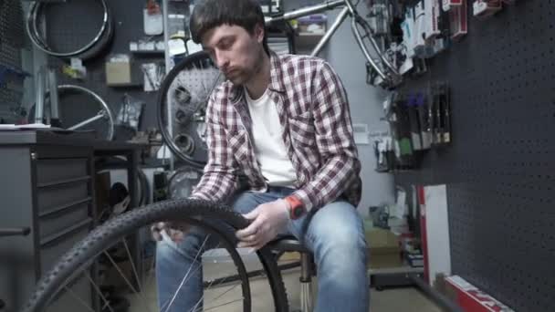 Mechaniker Seinem Arbeitsplatz Der Fahrradwerkstatt Wechselt Einen Fahrradschlauch Hebt Und — Stockvideo
