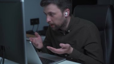 Kulaklıklı adam merkez ofiste video konferansı veriyor. Evden çalışan uzaktan kumandalı bir erkek ve masadaki bilgisayarla iş görüşmesi. Online eğitim seminerine katılan beyaz bir adam. Video çağrısı.