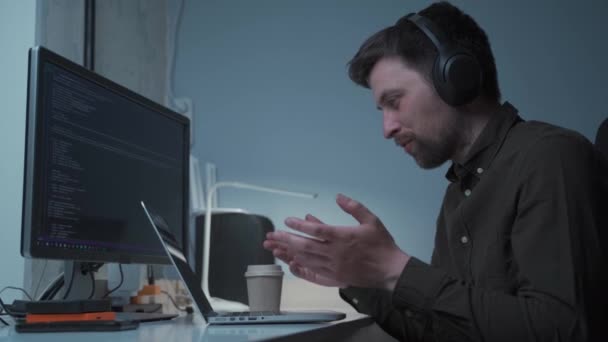 Programista Wykonuje Rozmowy Wideo Kolegami Przy Komputerze Przy Użyciu Słuchawek — Wideo stockowe