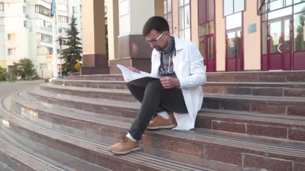 Студент Медик Сидит Лестнице Пределами Университета Изучает Медицинское Заключение Готовясь — стоковое видео