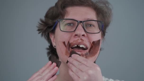 Μια Ενήλικη Γυναίκα Χαμένα Δόντια Πασαλείβει Σοκολάτα Στο Πρόσωπό Της — Αρχείο Βίντεο