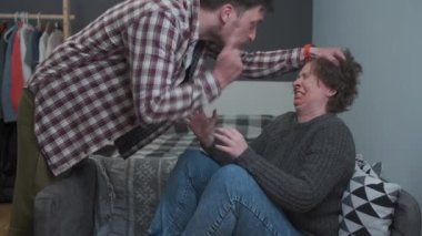 Domestic violence. Man shouts and humiliates woman by holding her hair and screams at home. Husband abuses his wife. Woman screaming while man is pulling her hair. Victim suffers from violent male 