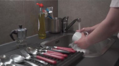 Mutfakta mutfak lavabosunu yıkayan ve temizlik sıvısı kullanan bir kadının yakın çekimi. Tema, ev işleri ve ev işleri. Ev temizliği, ev işleri. Ev işleri.
