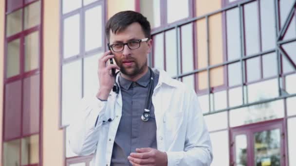 Young Male Doctor Wears Glasses Uses Smartphone Entrance Hospital Medical — Αρχείο Βίντεο