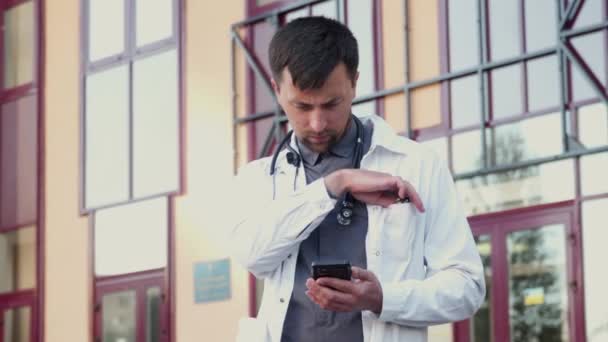Young Doctor White Lab Coat Wears Eyeglasses Surfs His Phone — Video