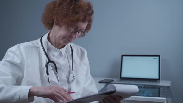 Старшая Женщина Врач Осматривает Медицинские Тесты Обследования Пациентов Больничном Кабинете — стоковое видео
