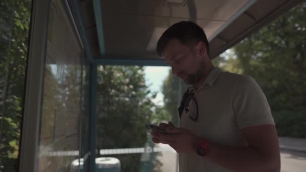 Attractive Young Caucasian Man Passenger Waiting Bus Stop Timetable Transport — Αρχείο Βίντεο
