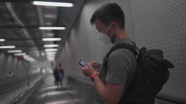 Passenger Wearing Protective Mask Descends Staircase Tube Uses His Phone — Stockvideo