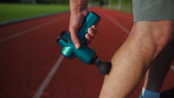 Athletic Male Massages Muscles Hand Massage Gun Recovering Stadium Running — ストック動画