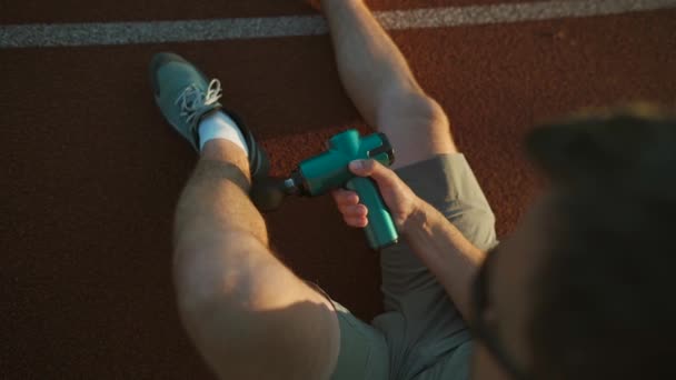 Male Athlete Massages Muscles Tendons Massage Percussion Device Workout Stadium — Vídeo de stock