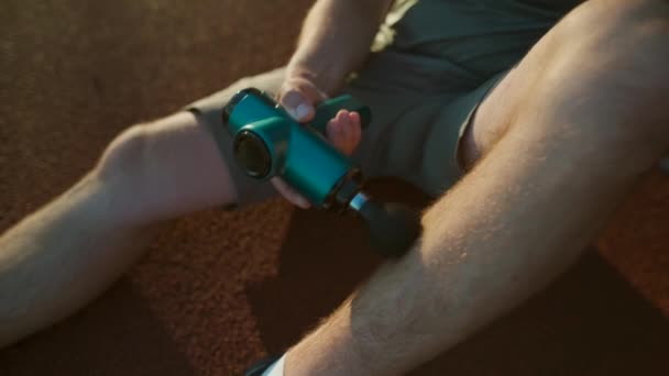 Athletic Male Massages Muscles Hand Massage Gun Recovering Stadium Running — Vídeo de stock