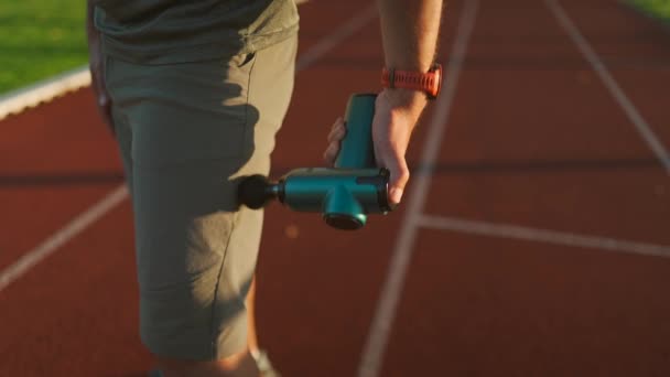 Athletic Male Massages Muscles Hand Massage Gun Recovering Stadium Running — Videoclip de stoc