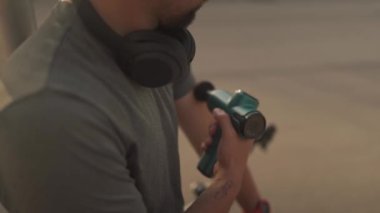 Cyclist use massage gun for deep percussive muscle massage. Hand massager for athletes, portable electric sports massager, hand massager for deep tissue. Muscle recovery and rehabilitation 