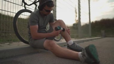 Cyclist use massage gun for deep percussive muscle massage. Hand massager for athletes, portable electric sports massager, hand massager for deep tissue. Muscle recovery and rehabilitation 