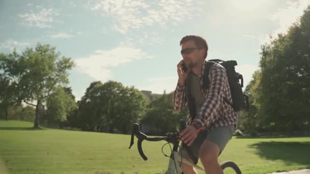 Muž Cyklista Batohem Projíždí Létě Cyklostezku Parku Mluví Svém Mobilním — Stock video
