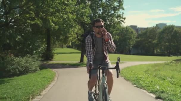 Ciclista Masculino Com Mochila Monta Ciclovia Parque Verão Fala Seu — Vídeo de Stock
