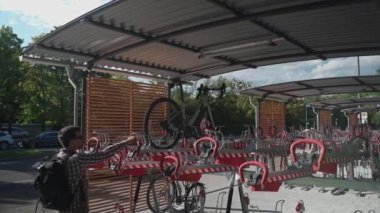 Bisiklet altyapısı. Bir adam Münih, Almanya 'da çift katlı bisiklet parkı kullanıyor. Erkek bisikletini iki katlı bisiklet parkına park eder. Avrupa 'da modern iki katlı bisiklet parkı 