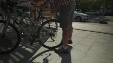 Adam bisikletini Münih, Almanya 'da iki katlı bir bisiklet parkına park ediyor. Çift katlı bisiklet parkı. Bisikletçi bisikletini ikiye bölünmüş bir bisiklet parkına park ediyor. Altyapı döngüsü