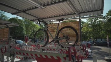 Bir adam bisikletini Almanya 'nın Münih kentindeki çok katlı modern bir bisiklet parkına park ediyor. Bisikletçi, iki kattaki park yerinin dışında bisiklet kenti kullanıyor. Bir erkek bisikletini iki sıra halinde park yerine koyar.