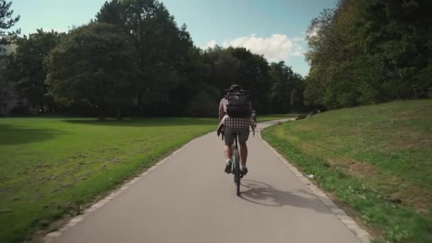 남자가 셔츠를 배낭을 자전거를 공원에서 자전거 도로를 달리고 자전거를 학생들은 — 비디오