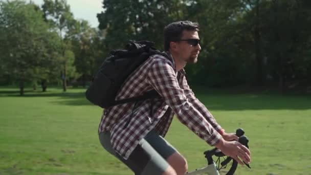 Cara Elegante Uma Camisa Com Uma Mochila Monta Uma Bicicleta — Vídeo de Stock