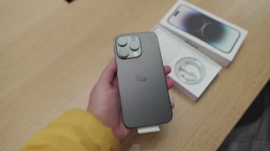 16 Eylül 2022, Münih, Almanya. Münih 'in merkezindeki Apple mağazasında yeni iPhone 14 satışının ilk günü. Resmi mağazadan satın alındıktan sonra yeni iPhone 14 Pro 'yu açmak ve açmak