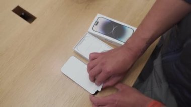16 Eylül 2022, Münih, Almanya. Münih 'in merkezindeki Apple mağazasında yeni iPhone 14 satışının ilk günü. Resmi mağazadan satın alındıktan sonra yeni iPhone 14 Pro 'yu açmak ve açmak