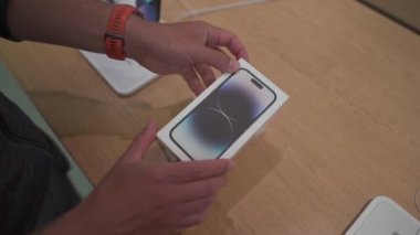 16 Eylül 2022, Münih, Almanya. Münih 'in merkezindeki Apple mağazasında yeni iPhone 14 satışının ilk günü. Resmi mağazadan satın alındıktan sonra yeni iPhone 14 Pro 'yu açmak ve açmak
