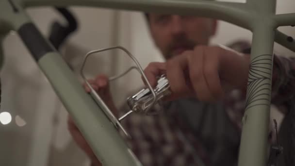 Jovem Instala Acessório Bicicleta Casa Apartamento Estúdio Homem Monta Uma — Vídeo de Stock