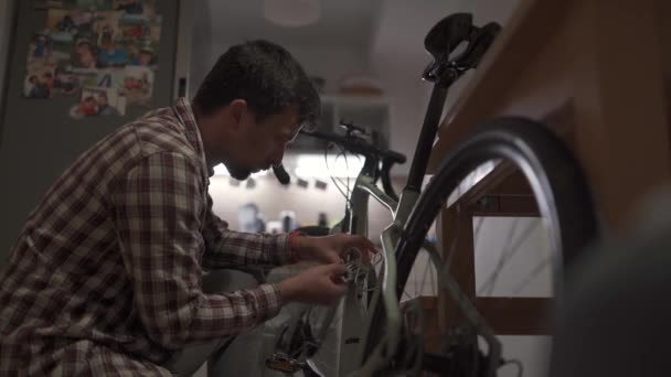 Jovem Instala Acessório Bicicleta Casa Apartamento Estúdio Homem Monta Uma — Vídeo de Stock