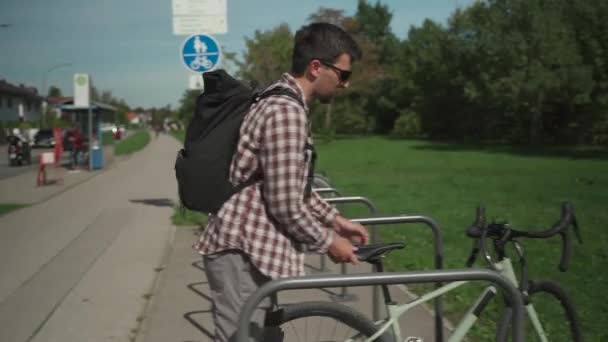 サイクリストパークとドイツの公共自転車駐車場で自転車をロックします 安全と輸送 路上駐車で自転車をロックする男 サイクル駐車場の盗難防止ロックを閉じるためのコンピュータの使用キー — ストック動画